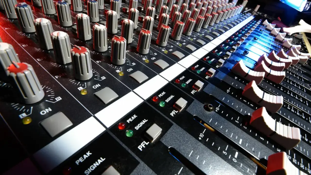 Console de mixage audio, avec ses potentiomètres et faders, prête pour le mastering gratuit.