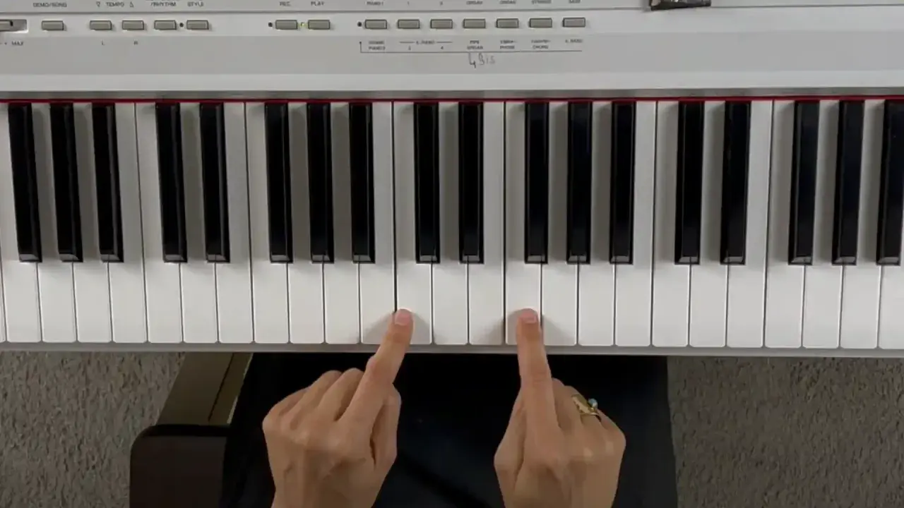 Deux doigts jouent un accord de piano.
