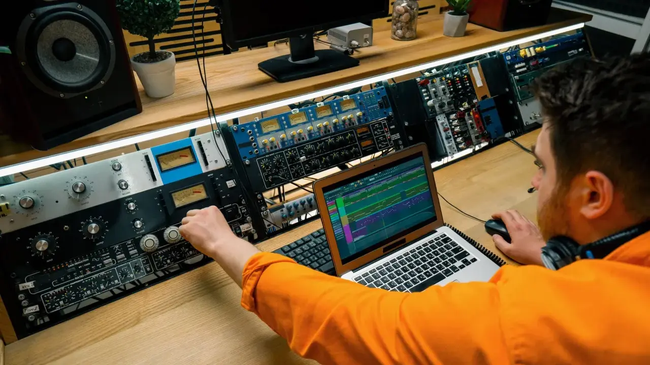 Un ingénieur du son ajuste les réglages sur une console audio, maîtrisant son studio pour un mixage parfait.