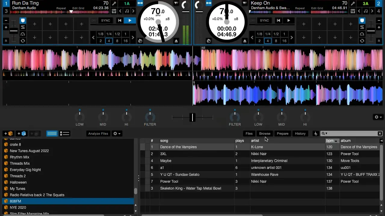 Interface d'un logiciel de mixage DJ avec deux platines virtuelles, formes d'ondes colorées et une liste de morceaux.