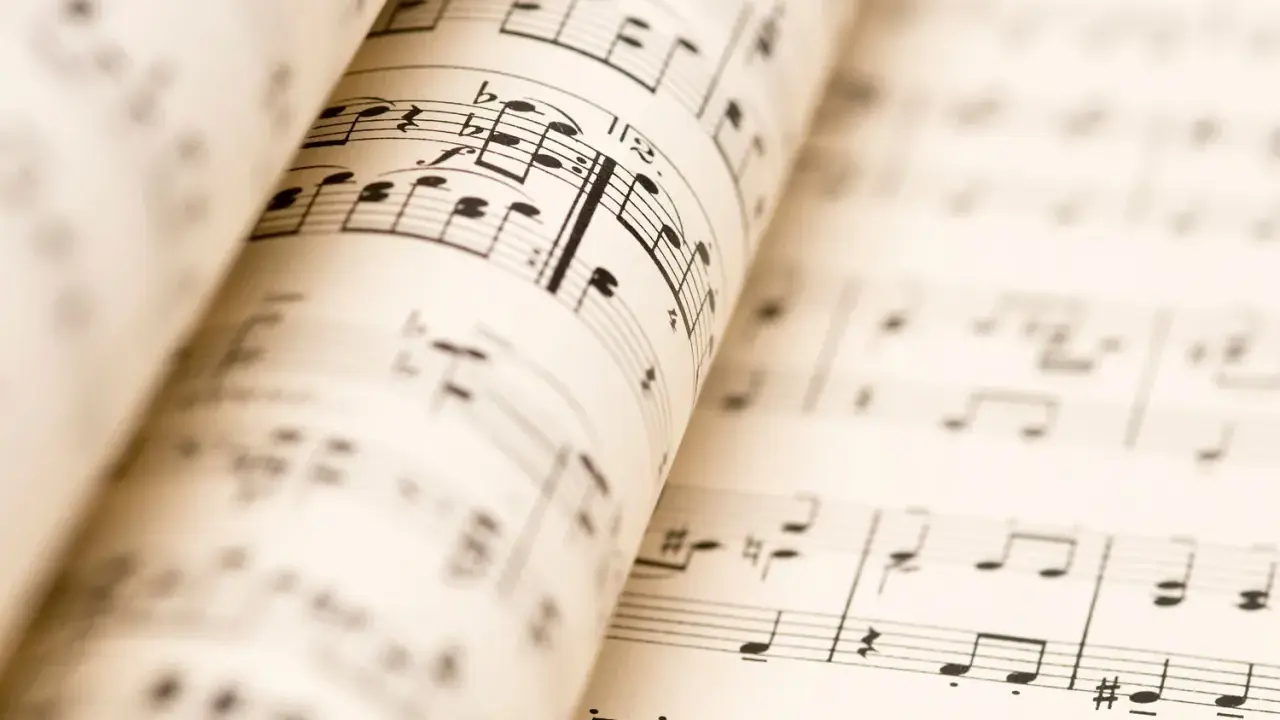 Partitions musicales ouvertes, révélant les nuances de la musique. Les notes et les portées se déploient, invitant à l'interprétation.