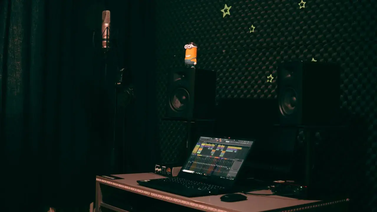 Studio d'enregistrement avec micro, casque, enceintes, un Minion et un ordinateur affichant une table de mixage. Le **midi out** est prêt pour la création musicale.