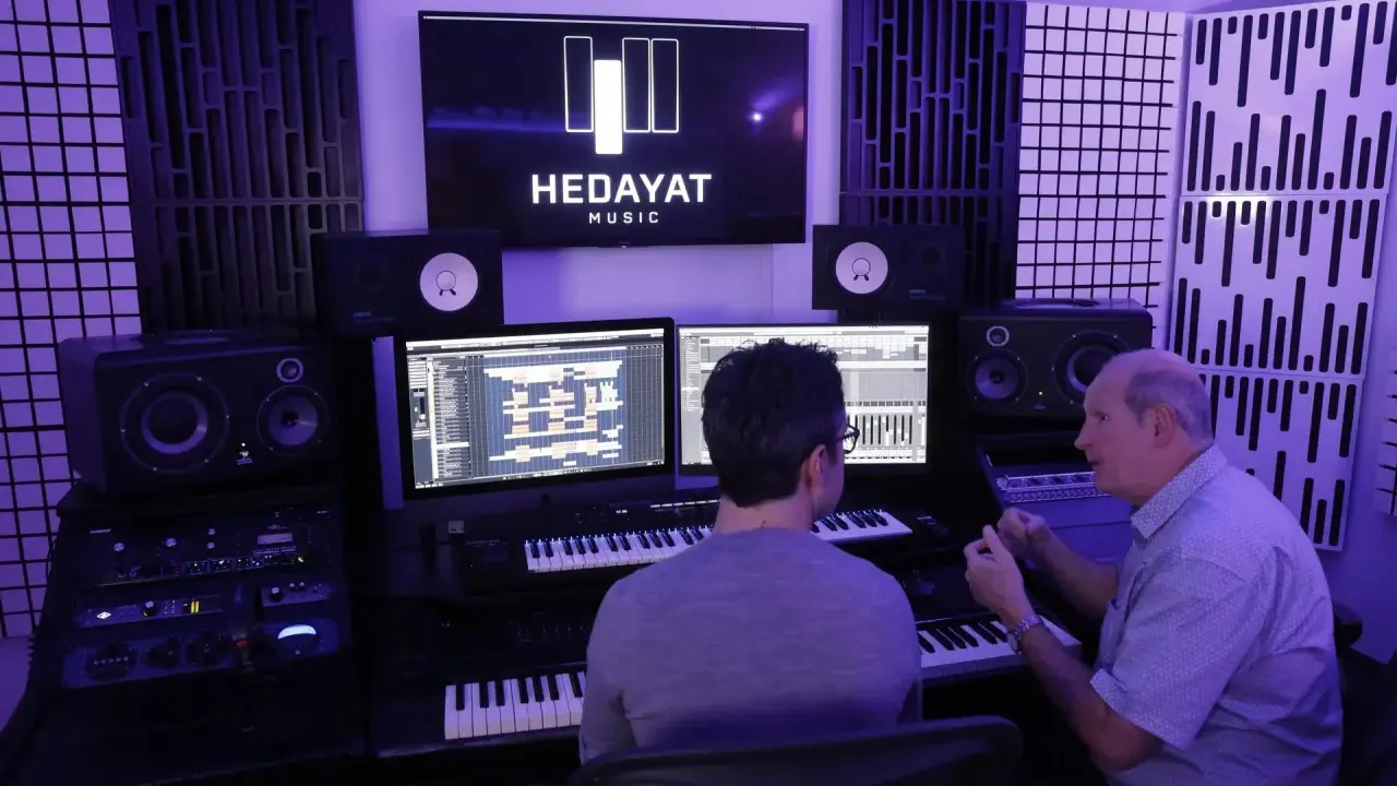 Deux hommes travaillent dans un studio d'enregistrement, le logo HEDAYAT MUSIC est visible sur un écran.
