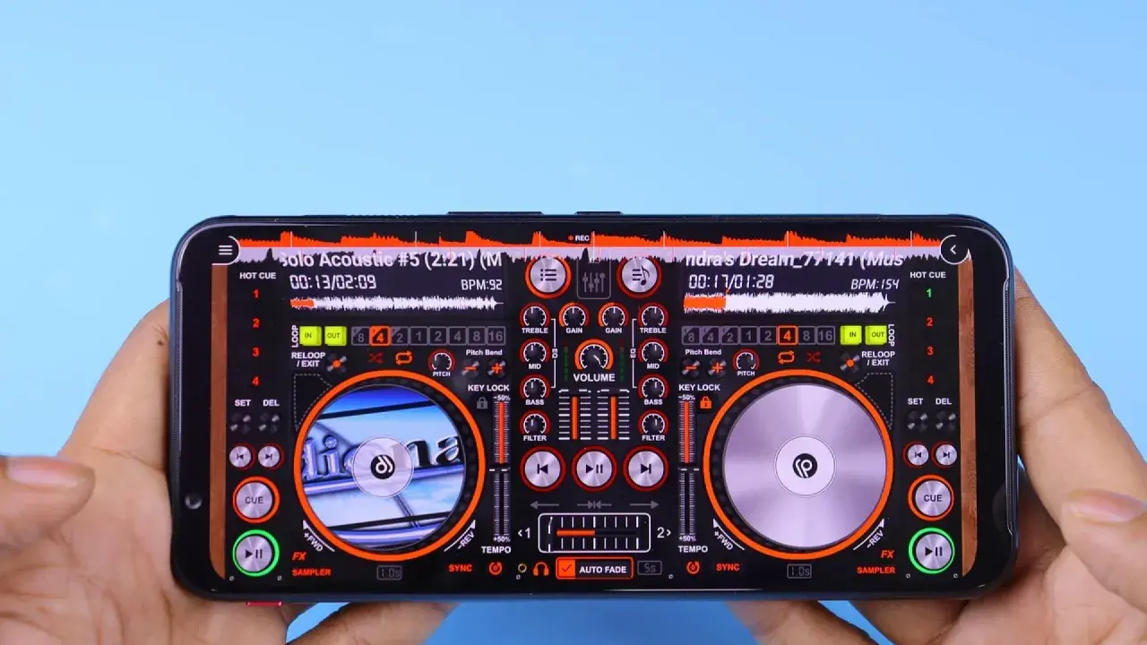 Mains DJ sur smartphone, avec une interface de mixage affichant deux platines et des contrôles. Un raccourci enregistrer est visible en haut à droite.