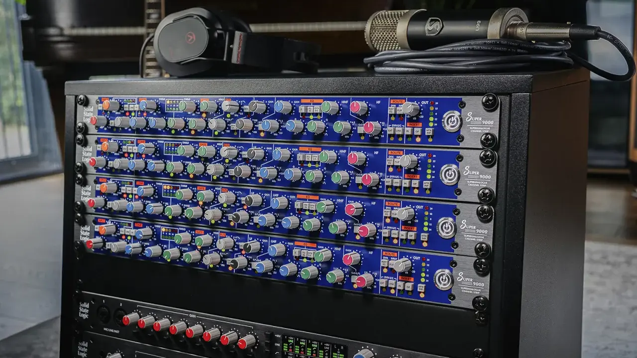 Rack de matériel audio avec plusieurs modules SSL Super 9000, un microphone et un casque.