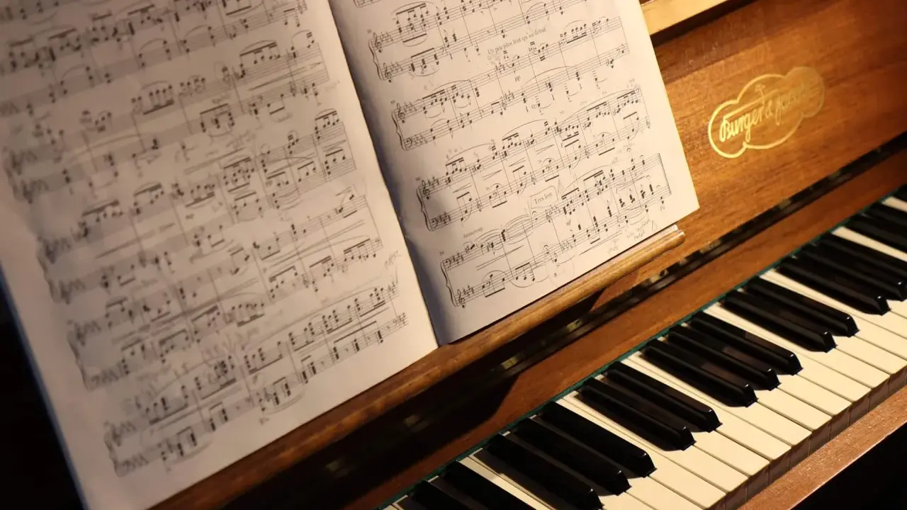 Partition de piano ouverte sur un clavier, évoquant le top 10 des morceaux de piano les plus difficiles.