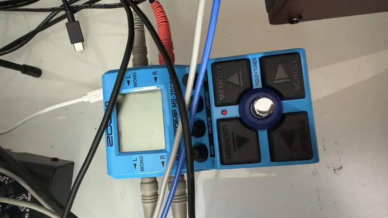 Pédalier Zoom MS-70CDR bleu avec câbles. Les entrées sont marquées L MONO et R, suggérant des options mono et stéréo pour le traitement du son.