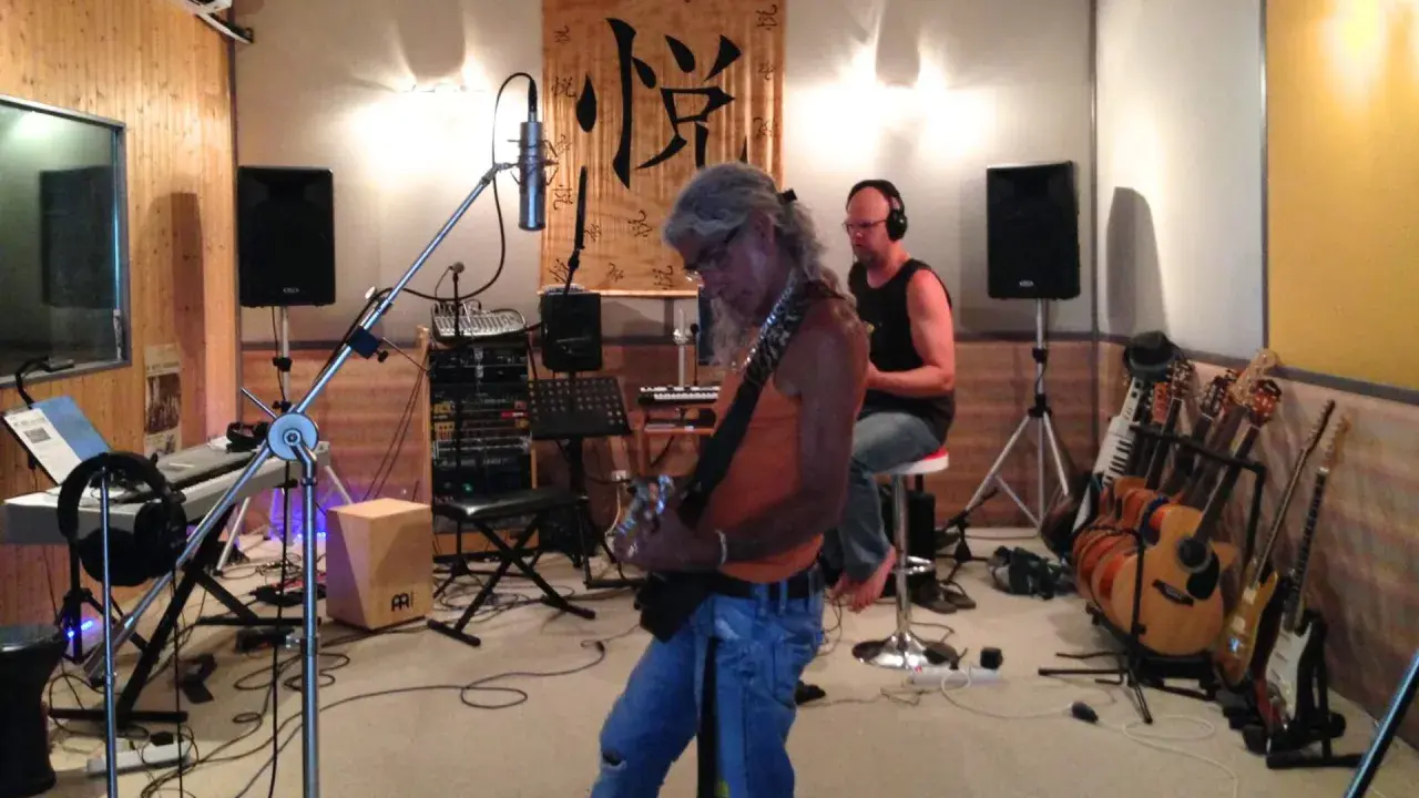 Un groupe enregistre dans un studio, prêt à injecter une touche de french touch musique. Guitares, claviers et micros sont prêts.