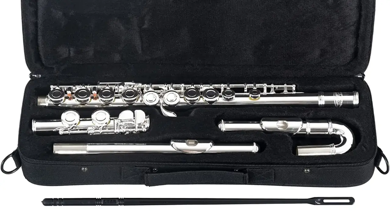 Étui ouvert révélant un gros instrument à vent argenté, une flûte traversière, démontée en plusieurs parties, prête pour la musique.