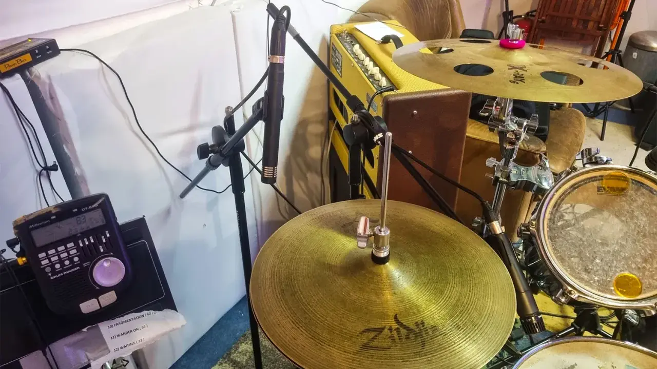 Un micro est positionné pour capter le son d'une batterie acoustique, prêt à enregistrer le rythme.