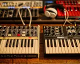 Deux synthétiseurs, l'un blanc et l'autre noir, sont alignés. Leurs claviers et boutons invitent à explorer les mondes analogique et numérique de la musique.