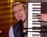 Un chanteur interprète une musique à faire au piano, sa voix résonne dans la salle.