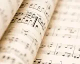 Partitions musicales ouvertes, révélant les nuances de la musique. Les notes et les portées se déploient, invitant à l'interprétation.