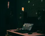 Studio d'enregistrement avec micro, casque, enceintes, un Minion et un ordinateur affichant une table de mixage. Le **midi out** est prêt pour la création musicale.