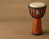 Un djembé Toca, un instrument de percussions africaines, repose sur un fond en bois.