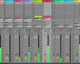 Tableau de mixage audio, avec des pistes nommées KICK, TOMS, etc. Les curseurs de volume sont visibles, certains en cours de mastering chain.