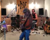 Un groupe enregistre dans un studio, prêt à injecter une touche de french touch musique. Guitares, claviers et micros sont prêts.