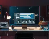 Studio d'enregistrement avec ordinateur affichant une station de travail audio numérique, un clavier, des enceintes et un pad de batterie, le tout constituant du matériel pour composer musique électronique.