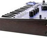 Clavier synthétiseur mini nova avec finitions bois sombre et panneau bleu lumineux.