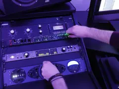 Main d'un ingénieur du son ajustant un compresseur Universal Audio 1176LN, dans un studio d'enregistrement.