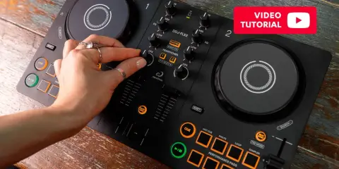 Main d'une personne manipulant une table de mixage pour créer sa propre musique électro. Tutoriel vidéo disponible.