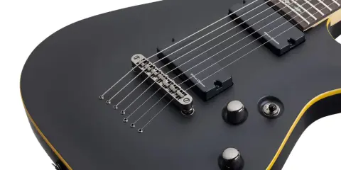 Guitare électrique Schecter Demon 7 noire, avec ses 7 cordes prêtes à rugir.