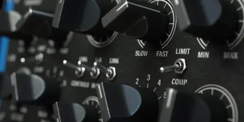 Gros plan sur les boutons et interrupteurs d'un compresseur audio. Réglages d'attaque, de seuil et de ratio sur cet équipement de studio.