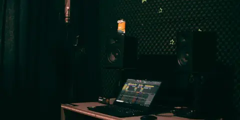 Studio d'enregistrement avec micro, casque, enceintes, un Minion et un ordinateur affichant une table de mixage. Le **midi out** est prêt pour la création musicale.