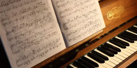 Partition de piano ouverte sur un clavier, évoquant le top 10 des morceaux de piano les plus difficiles.