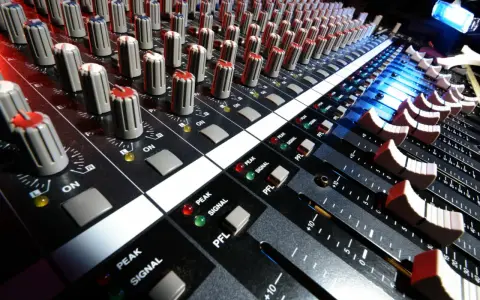 Console de mixage audio, avec ses potentiomètres et faders, prête pour le mastering gratuit.