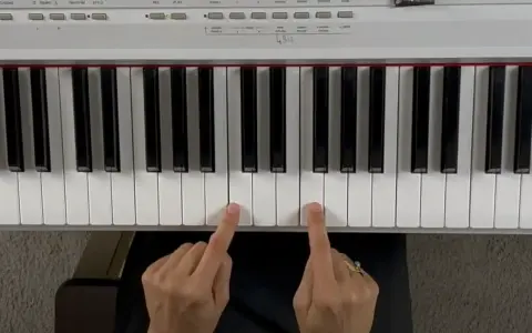 Deux doigts jouent un accord de piano.