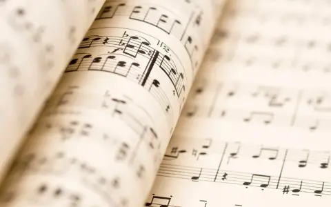 Partitions musicales ouvertes, révélant les nuances de la musique. Les notes et les portées se déploient, invitant à l'interprétation.