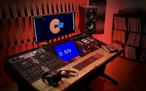 Studio d'enregistrement avec console, moniteurs Focal, casque et platine vinyle. L'équipement est prêt pour un son **lossless audio** parfait.