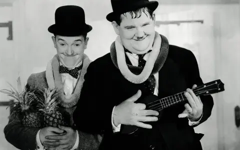 Laurel et Hardy, l'un tenant des ananas, l'autre jouant d'un ukulélé, évoquent l'origine hawaïenne de cet instrument.