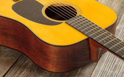 Guitare acoustique Martin D18, bois de palissandre et épicéa, sur fond de bois vieilli.