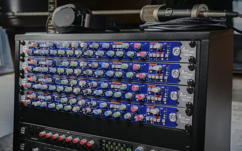 Rack de matériel audio avec plusieurs modules SSL Super 9000, un microphone et un casque.
