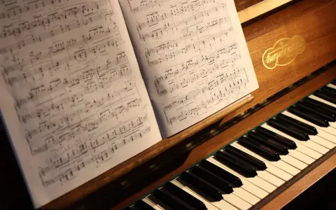 Partition de piano ouverte sur un clavier, évoquant le top 10 des morceaux de piano les plus difficiles.
