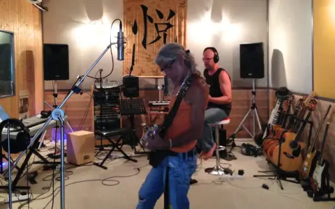 Un groupe enregistre dans un studio, prêt à injecter une touche de french touch musique. Guitares, claviers et micros sont prêts.