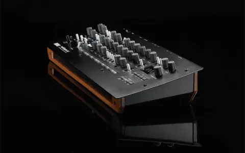 Synthétiseur Korg minilogue xd noir avec finitions bois, posé sur une surface réfléchissante.