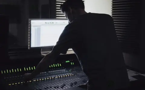 Un ingénieur du son ajuste la console, créant un mixage audio de qualité mp3 320 kbps.