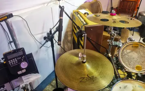 Un micro est positionné pour capter le son d'une batterie acoustique, prêt à enregistrer le rythme.