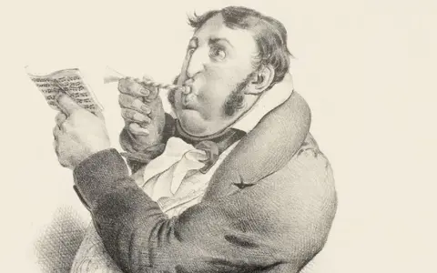 Un homme soufflant dans une trompette, lisant une partition. Un jargon, une définition de ce terme.
