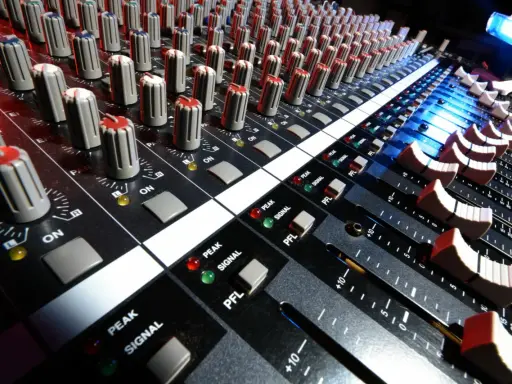 Console de mixage audio, avec ses potentiomètres et faders, prête pour le mastering gratuit.