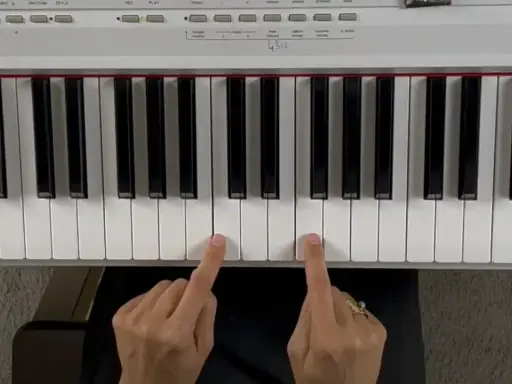 Deux doigts jouent un accord de piano.