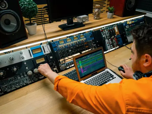 Un ingénieur du son ajuste les réglages sur une console audio, maîtrisant son studio pour un mixage parfait.