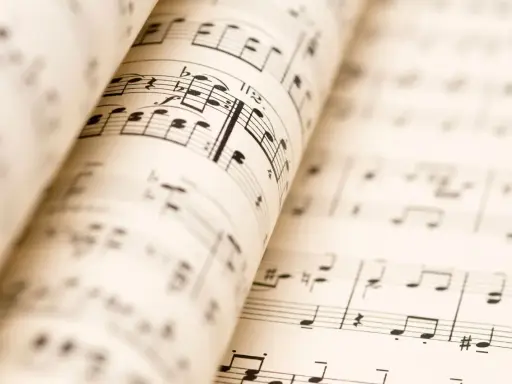 Partitions musicales ouvertes, révélant les nuances de la musique. Les notes et les portées se déploient, invitant à l'interprétation.