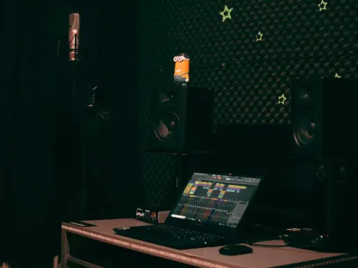 Studio d'enregistrement avec micro, casque, enceintes, un Minion et un ordinateur affichant une table de mixage. Le **midi out** est prêt pour la création musicale.