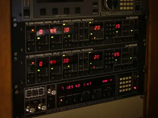 Rack d'équipements audio avec écrans numériques affichant des réglages de delay et de pré-réglages. Le delay est réglé sur 20.