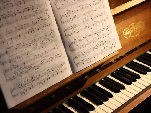 Partition de piano ouverte sur un clavier, évoquant le top 10 des morceaux de piano les plus difficiles.
