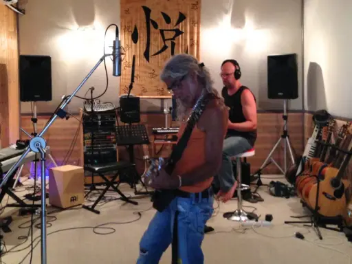 Un groupe enregistre dans un studio, prêt à injecter une touche de french touch musique. Guitares, claviers et micros sont prêts.